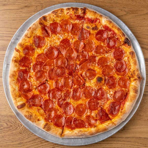 A whole pepperoni pizza on a metal pan, with a golden crust and melted cheese.